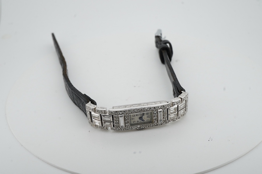 An Art Deco lady's diamond cocktail watch, 1930s, the rectangular silvered dial with blue steel hands, in a geometric case set with circular-cut and baguette diamonds, mounted in platinum, case width 1cm excluding winder